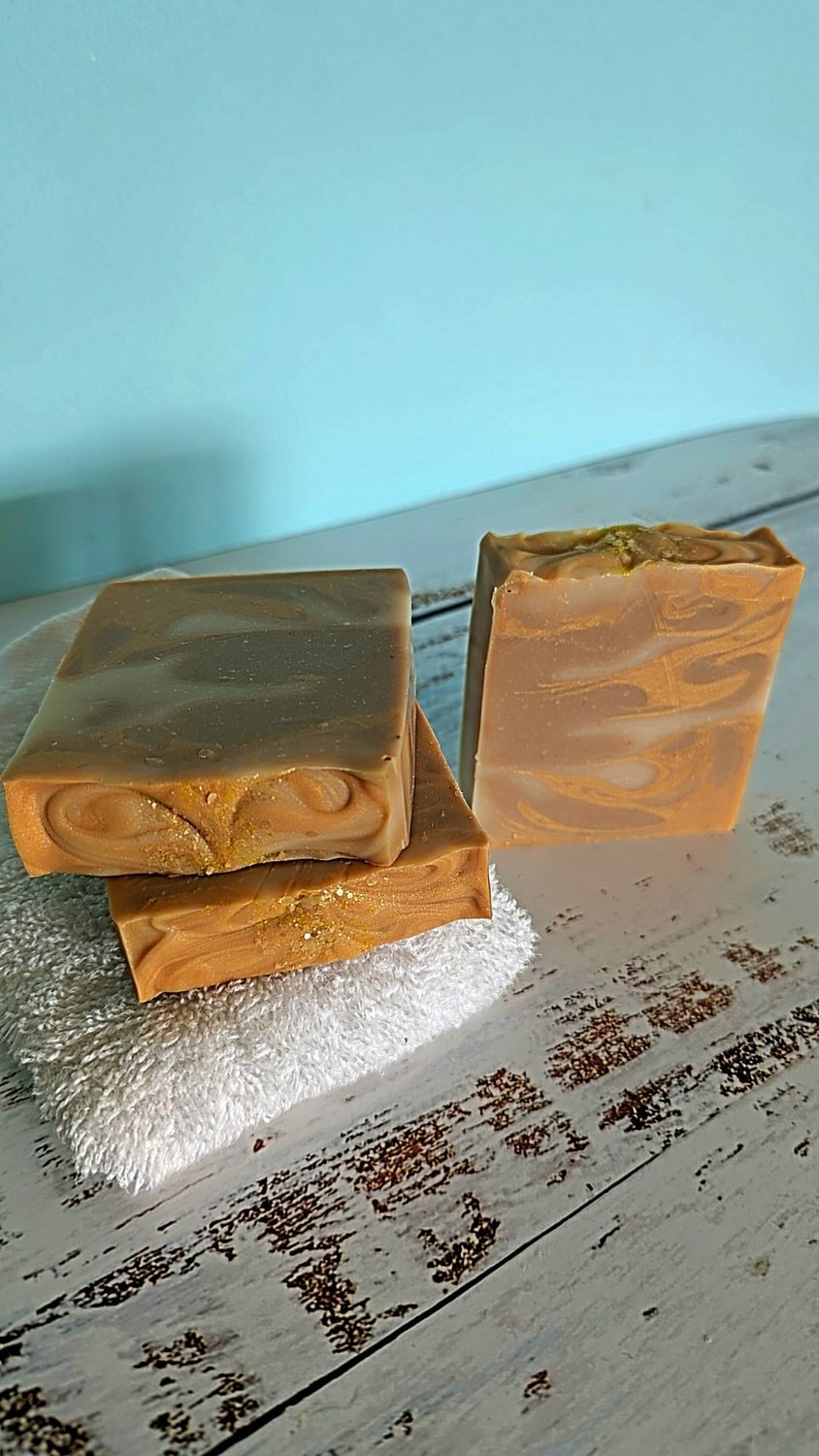 Calm Comfort Soap Three bars of soap, two stacked, one standing, on a white surface with a blue background.